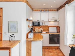 a small kitchen with white cabinets and a counter at Steinbeck in the Thorstorf estate barn in Thorstorf