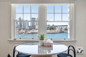 a table and chairs in a room with a window at KozyGuru | MacMahons Point | Harbour Hideaway in Sydney