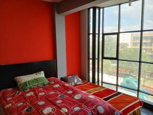 a bedroom with a bed and a large window at Departamento Céntrico in Quillacollo
