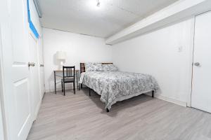 een slaapkamer met een bed en een tafel met een stoel bij Bright & Spacious 2 Bedroom Apartment Free Wi-Fi, Free Parking, Near Nature Trails in Toronto