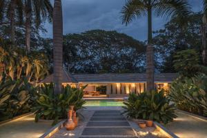 a house with a swimming pool and palm trees at Arde La Selva in Santa Fe de Antioquia