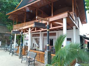 a building with a porch with chairs on it at SeaGarden Guesthouse in Bunaken