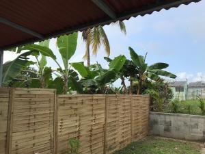 レ・トロワ・イレにあるGrand F2 luxe 3 mn plage avec jardin pointe du boutの木の柵