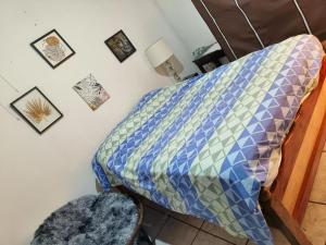 a bed with a quilt on it in a room at Mi Casita en Sivar in Apopa