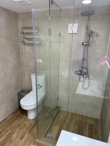 a bathroom with a toilet and a glass shower at San Alfonso del Mar 7P in Algarrobo +11 photos