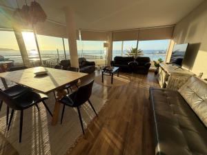 a living room with a couch and a table and chairs at San Alfonso del Mar 7P in Algarrobo