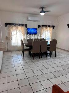 a dining room with a table and chairs on a tiled floor at Flores Condominios Casa Narciso in Álamos +11 photos