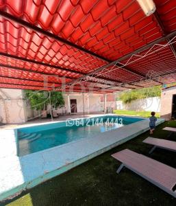 a swimming pool in a building with a red roof at Flores Condominios Casa Narciso in Álamos