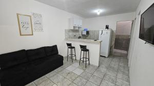 a living room with a couch and a kitchen at Casa com 2 Quartos e Garagem, Alto da Cruz, Camaçari in Camaçari