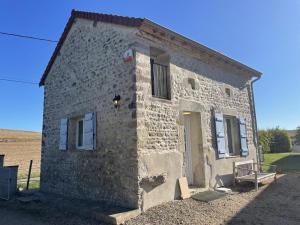 a small stone building with a door on the side at Gîte de Charme avec Jardin et Animaux Admis - FR-1-489-595 in Valignat +7 photos