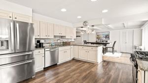 a kitchen with white cabinets and stainless steel appliances at Lagoon Front 4 Bedroom Beat The Crowds in Beach Haven West