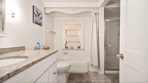 a white bathroom with a toilet and a sink at Lagoon Front 4 Bedroom Beat The Crowds in Beach Haven West +21 photos