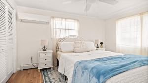 a white bedroom with a bed and a window at Lagoon Front 4 Bedroom Beat The Crowds in Beach Haven West
