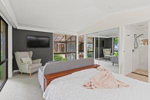 a bedroom with a bed and a living room at Tamborine Mountain Lodge in Mount Tamborine