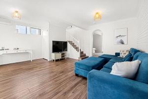 a living room with a blue couch and a tv at Shelleys - Pet Friendly - Short Walk to Beach in Orient Point