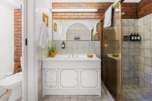 a bathroom with a white sink and a shower at Shelleys - Pet Friendly - Short Walk to Beach in Orient Point +14 photos