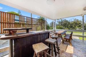 an outdoor bar with wooden chairs and tables on a deck at Shelleys - Pet Friendly - Short Walk to Beach in Orient Point