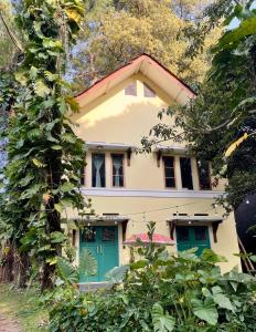 a house with a green door and trees at MiTS in Bandung