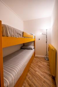 a bedroom with two bunk beds and a lamp at Cervinia Ski In Ski Out - Peak Studio in Breuil-Cervinia