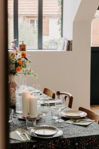 einen Tisch mit Kerzen, Tellern und Gläsern in der Unterkunft Domaine des Pousses, gîte au coeur d'un village de campagne in Droue-sur-Drouette