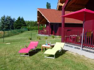 Un grupo de sillas y una mesa frente a un edificio. en Gîtes cosy au coeur du bocage avec draps & serviettes inclus - FR-1-489-93, en Meillard