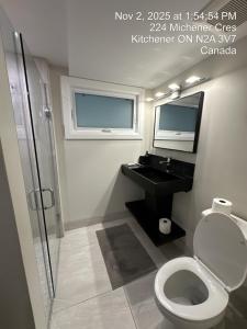 ein Badezimmer mit Toilette, Waschbecken und Spiegel in der Unterkunft Spacious 2 Bedroom & 2 Bathroom Suit Near Fairview Mall & Waterloo Airport in Kitchener + 53 Fotos