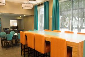 サンアントニオにあるHeritage Inn Suites San Antonio Airpt, Trademark by Wyndhamの大きな木製テーブルと椅子付きの会議室