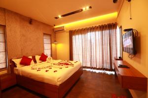 een slaapkamer met een bed en een groot raam bij Bonita Banasura in Vythiri