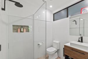 a bathroom with a toilet and a glass shower at Tamborine Mountain Lodge in Mount Tamborine +16 photos