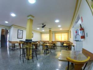 a restaurant with tables and chairs in a room at Hotel Graunas in São Carlos