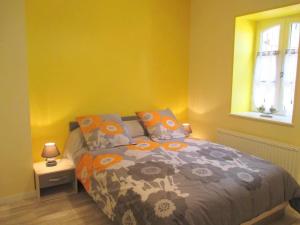 a bedroom with a bed with orange and yellow walls at Deux maisons rénovées sur ferme active avec spa et salle de jeux - FR-1-489-442 in Cressanges