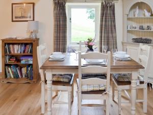 a dining room with a table and chairs and a window at Brow View Cottage in Ravenstonedale