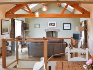 a living room with a fireplace and wooden beams at Brow View Cottage in Ravenstonedale