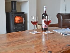 a table with two wine glasses and a bottle of wine at Gwelfor in Trearddur