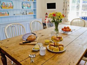 a wooden table with plates of food on it at Woodbrook Cottage in Bridport