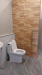 a bathroom with a toilet and a wooden wall at Bukettree homestay satun in Ban Khok +17 photos