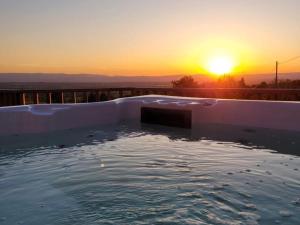 a swimming pool with the sunset in the background at Gîte chaleureux 8 pers, animaux admis, campagne verdoyante - FR-1-496-343 in Pouilly-les-Feurs