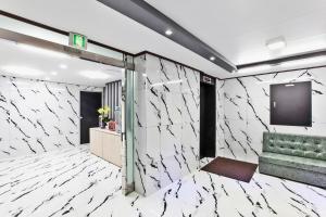 仁川にあるJuan 3&4 Hotelの白い大理石の壁とスクリーンのあるロビー