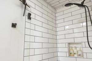 a shower with white subway tile in a bathroom at Tonquin Beach House - EV Charger, Wood Fireplace, Steps from beach in Tofino +51 photos