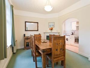 een keuken met een houten tafel en stoelen bij Bridge End - E1028 in Waxham