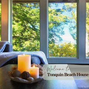 a table with candles in front of a window at Tonquin Beach House - EV Charger, Wood Fireplace, Steps from beach in Tofino