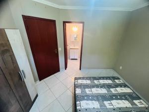a room with a bed in a room with a door at Medeiros in Capão da Canoa