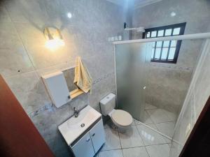 a white bathroom with a toilet and a sink at Medeiros in Capão da Canoa +15 photos