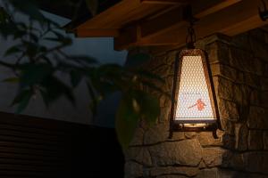 a light hanging from a stone wall at soyo-ka kyoto sanjo in Kyoto