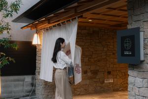 een vrouw kijkt uit een raam bij soyo-ka kyoto sanjo in Kyoto