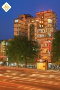 a building with a tree in front of a street at Hoa Hong Hotel - Xa Dan in Hanoi