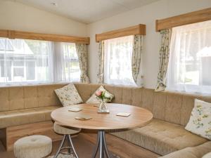 una sala de estar con un sofá y una mesa en Hillcrest Caravan - Uk44798, en Hemswell