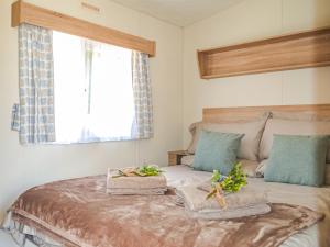 1 dormitorio con 1 cama con 2 toallas y una ventana en Hillcrest Caravan - Uk44798, en Hemswell