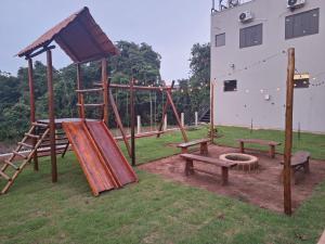 a park with a playground with benches and a slide at Mundial Chalés e Ecoturismo in Delfinópolis