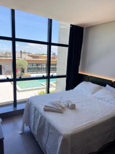 a bedroom with a bed with two towels on it at Loft em Xangri-Lá com piscina aquecida in Xangri-lá